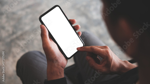 Close up view man holding mock up smart phone. Blank screen for your advertising text..