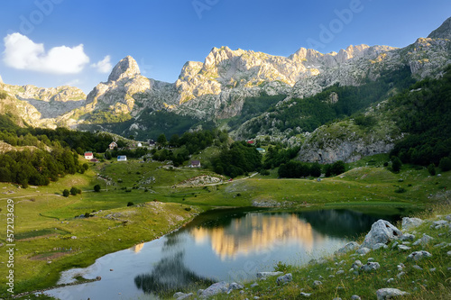 Scenic landscape of mountain valley with Bukumirsko Lake in alps of Montenegro. Stunning view of mountains and valleys in sunset light