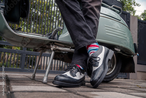 Wallpaper Mural These hand-made black-and-white wingtip shoes with loafers sole made from genuine leather are being worn to hang out with an old green Vespa	 Torontodigital.ca