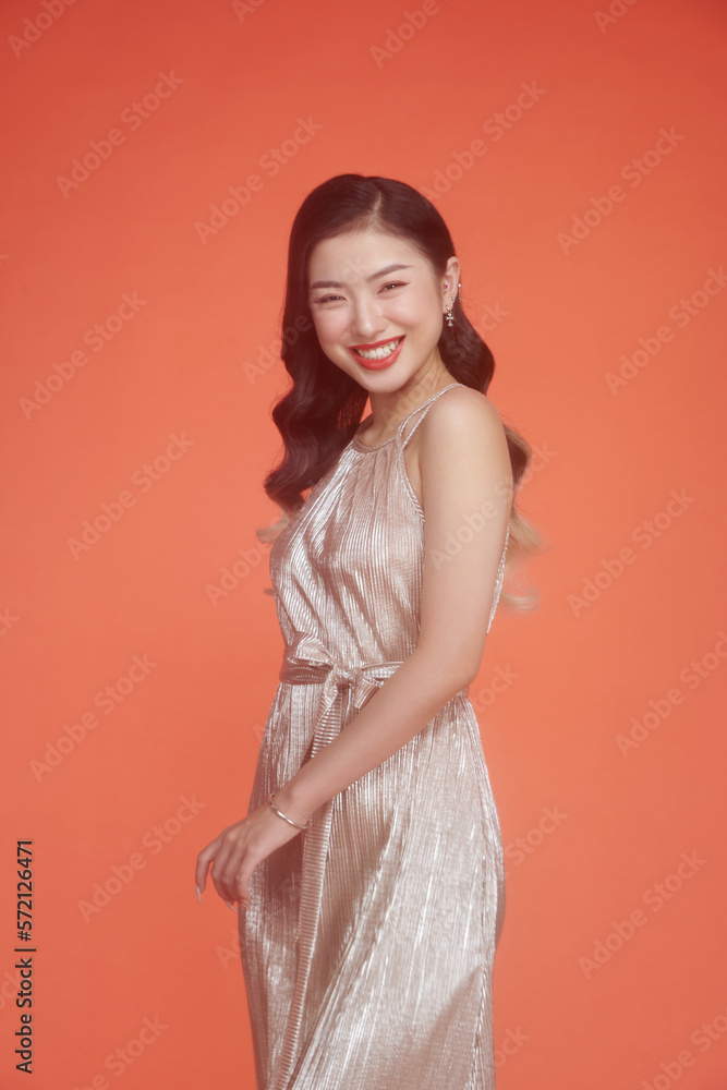 Portrait of a beautiful elegant woman in a glamour dress on red background Portrait of a beautiful elegant woman in a glamour dress on red background