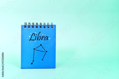 Libra zodiac sign on blue desk calendar notepad. Horoscope and astrology concept.