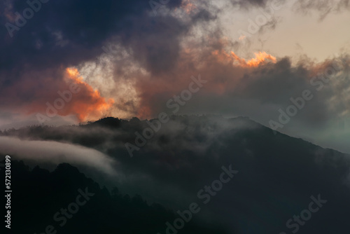 Colourful clouds above Himalayan mountain range after sun has set beyond the mountain peaks. After sun set nature stock image   shot at Okhrey  Sikkim  India.