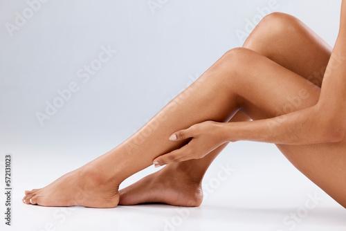 Cosmetics, skincare and legs with woman, dermatology and healthy lifestyle on grey studio background. Closeup, zoom and female with hair removal, salon treatment and luxury with pedicure and backdrop
