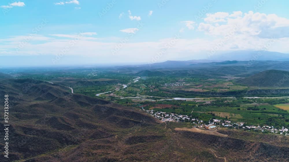 Flight over a valley with bright trees and fields against the backdrop of high mountains. Panoramic landscape of Dominican summer nature. Amazing high angle aerial top view of the natural park. Flight over a valley with bright trees and fields against the backdrop of high mountains. Panoramic landscape of Dominican summer nature. Amazing high angle aerial top view of the natural park.