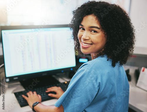 Portrait, nurse and receptionist at hospital on a computer working at her desk or table in an office as a black woman. Medical, healthcare professional or worker smile, happy and excited at work photo