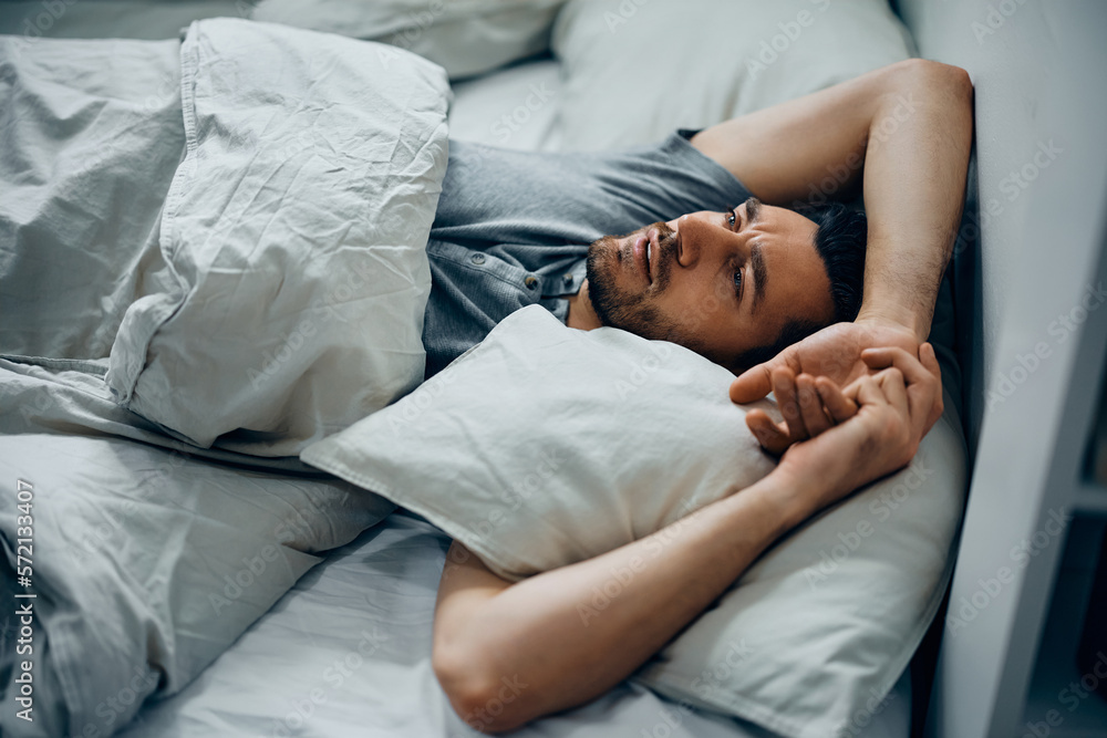 Thoughtful man lying down in bed. Thoughtful man lying down in bed.