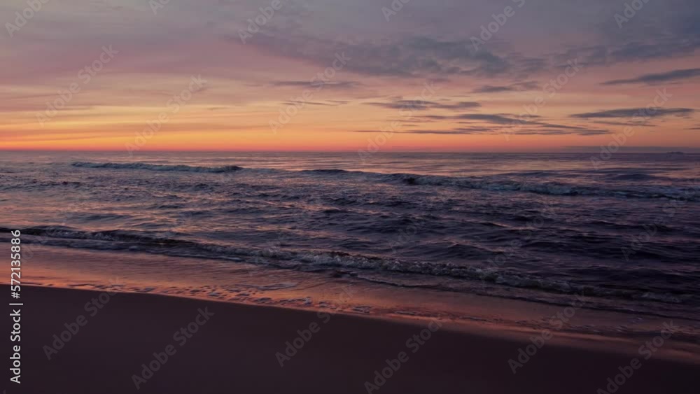 Dramatic sunset over sea in aerial dolly out revealing beach Dramatic sunset over sea in aerial dolly out revealing beach