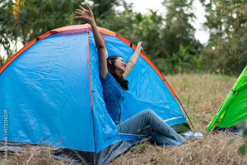 Happy Young Asian woman Relaxing with tent in nature at sunset.