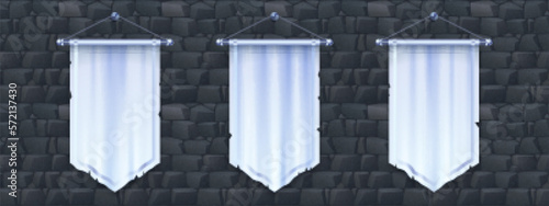 Blank vertical medieval flag mockup for game design. Isolated 3d white pennon hanging on stone wall background. Royal or knight vintage pennant with silver border, ragged edge