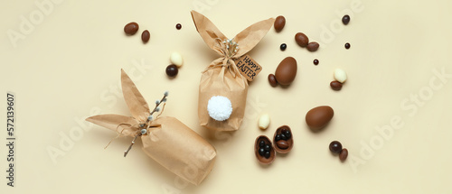 Easter gifts and chocolate eggs on beige background