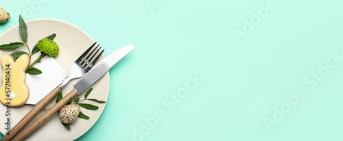 Photography Stylish table setting with Easter cookie and eggs on turquoise background with s