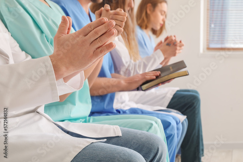 Group of doctors praying in clinic, closeup