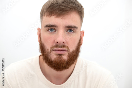 Portrait of bearded happy young handsome man with beard is smiling on white background and looking at camera