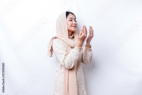 Religious beautiful Asian Muslim girl wearing a headscarf praying to God. photo