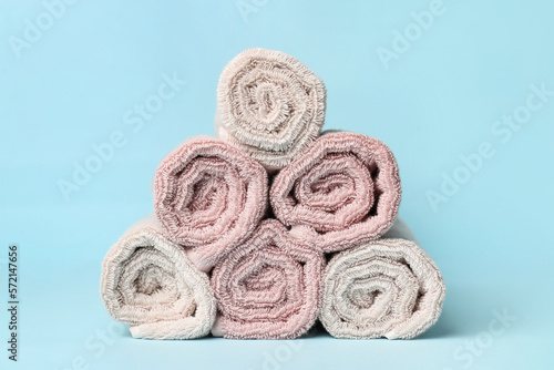 Heap of rolled towels on color background