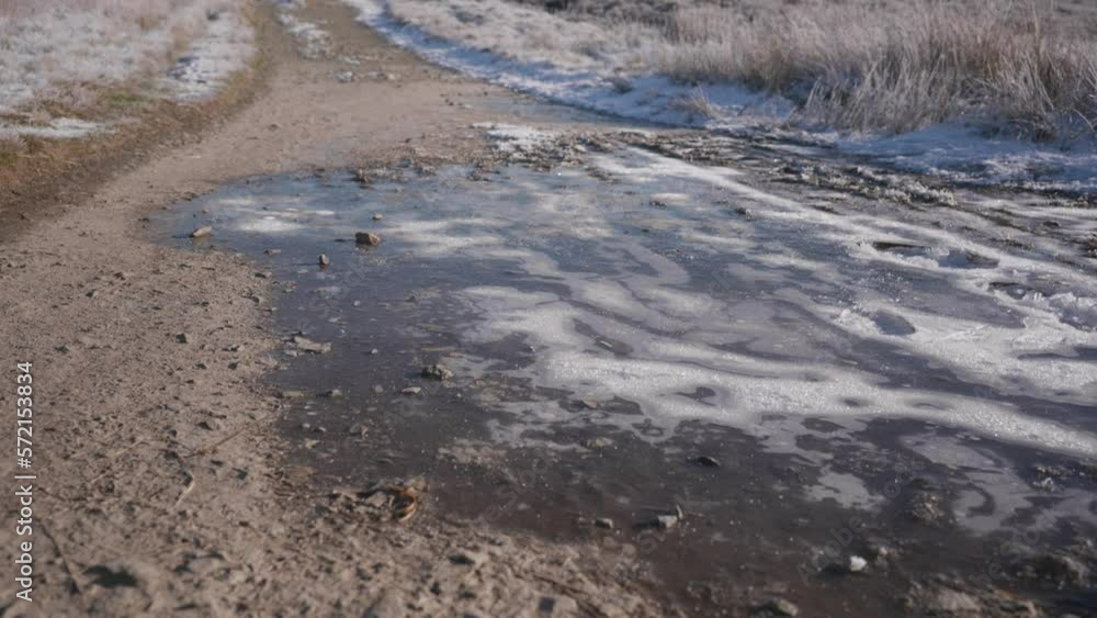 Two people hiking on a winter path through snowy moorland, walking over solid frozen ice and hard packed dirt. Two people hiking on a winter path through snowy moorland, walking over solid frozen ice and hard packed dirt.