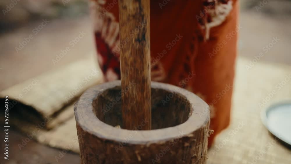 Traditional wooden mortar and pestle used to grind roasted coffee beans