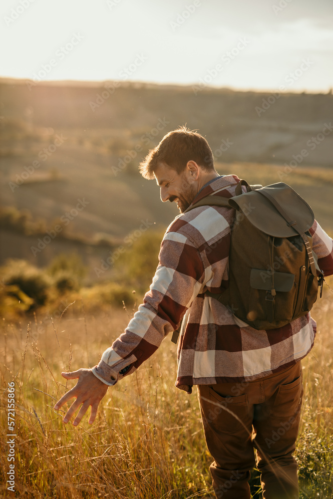 Young man hiking in nature. Hiker is Intone with nature.