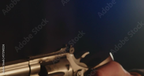 Close up of Finger pulling trigger of revolver and shooting. Smoke passes in front of the camera photo