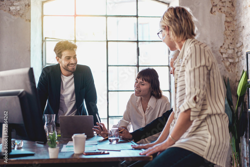 Group of Professionals Discussing in an Office - colleagues working happily in around the work desk