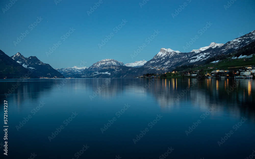 Alpine lake at dusk with Swiss Alps in the background