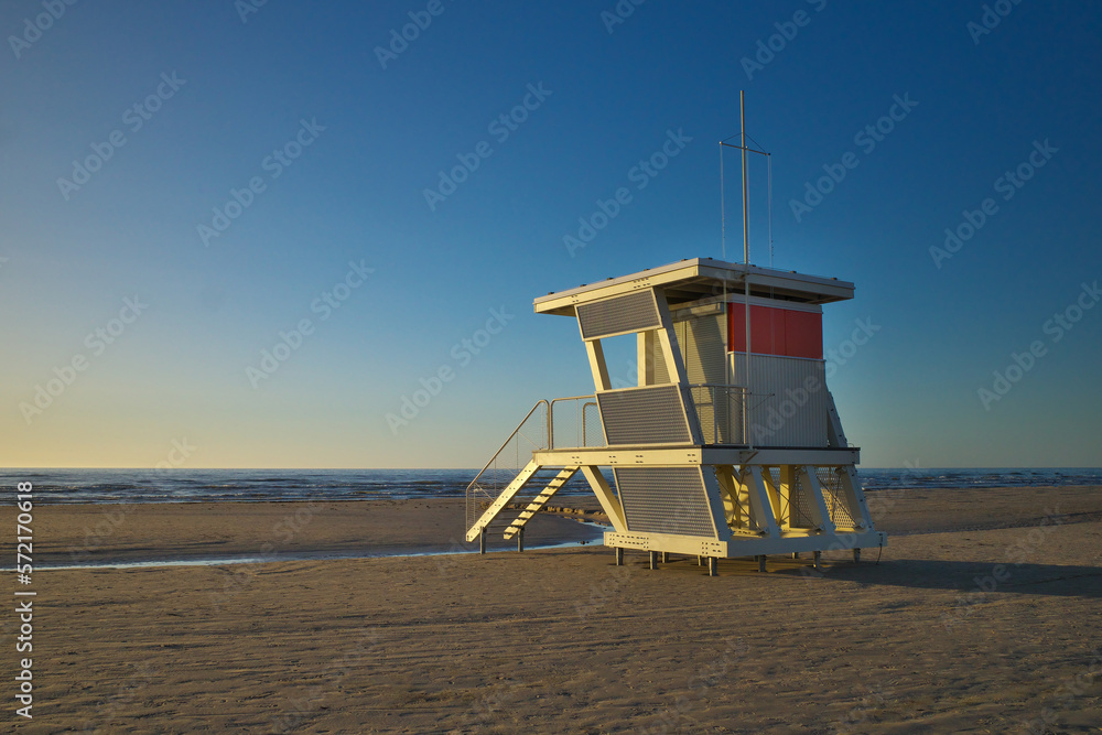 White life tower on the beach at sunset. White life tower on the beach at sunset.