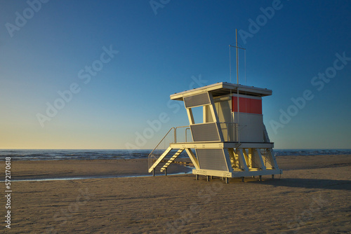 White life tower on the beach at sunset. © Igor