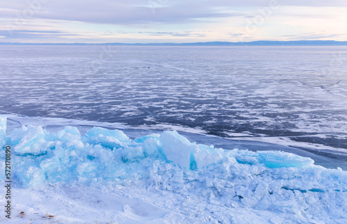 Baikal Lake in winter. Tall ice piles and blue icy hummocks formed along the coast as a result of the earthquake and ice impact. Natural phenomena. Winter beautiful landscape