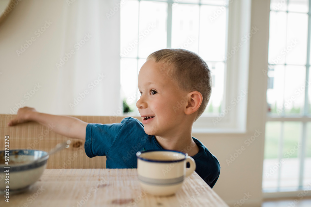 portrait of a young boy playing whilst at the breakfast table portrait of a young boy playing whilst at the breakfast table