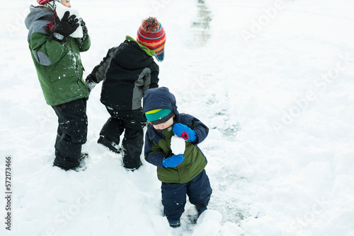 Wallpaper Mural Three brothers play outside making snowballs after winter storm Torontodigital.ca
