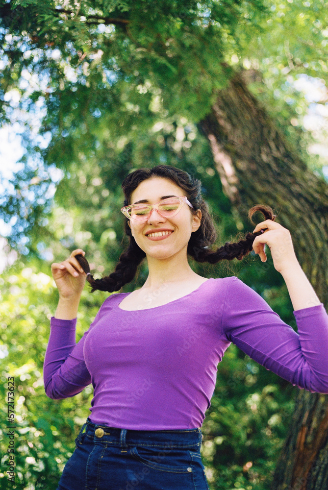 Happy female smiling holding her pigtails Happy female smiling holding her pigtails