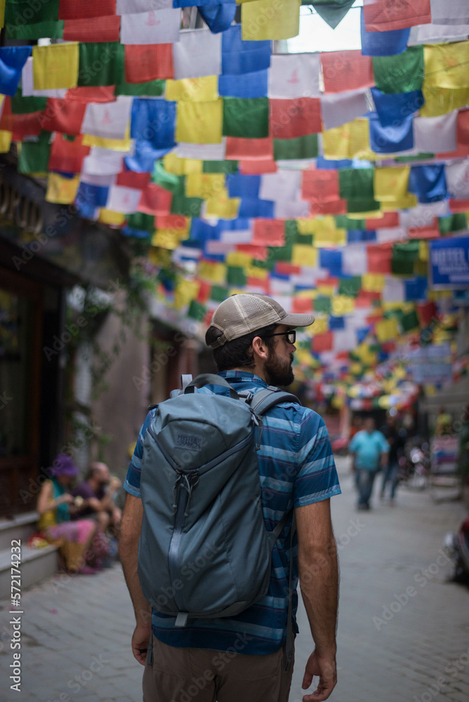 Young man walking streets of Nepal with Himalayan Flags Young man walking streets of Nepal with Himalayan Flags