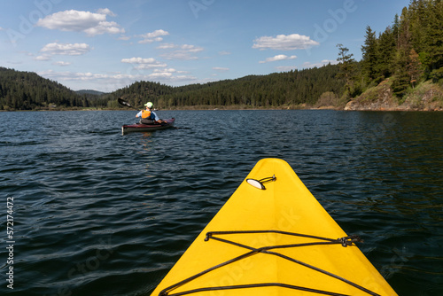 Kayaking in a yellow boat on Couer D'Alene Lake on a sunny spring day photo