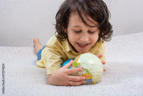 Happy preschooler boy discovering world as back to school concep photo