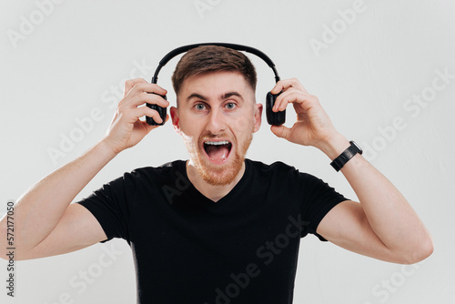 Happy man smiling listening to music in headphones. White background.
