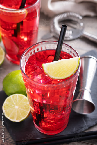 Cape Codder cocktail with vodka, cranberry juice and lime on wooden table