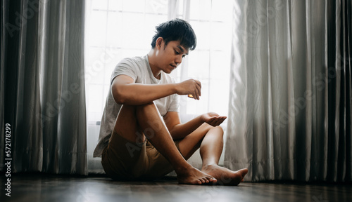 Asian Man sit Depression Dark haired pensive glance Standing by window and anxiety Copy space.
