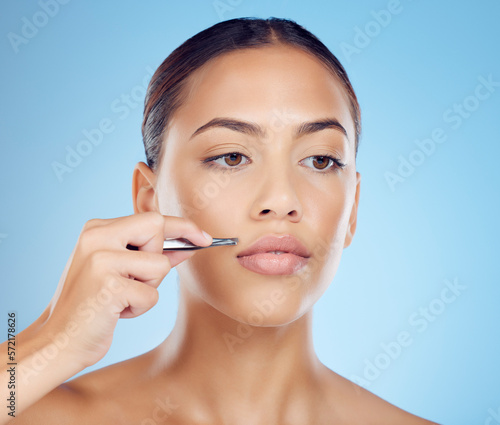 Tweezer  lip and hair removal with woman in studio for beauty  grooming and hygiene on blue background. Facial  moustache and product or tool for girl model with mouth  hairs and cleaning isolated
