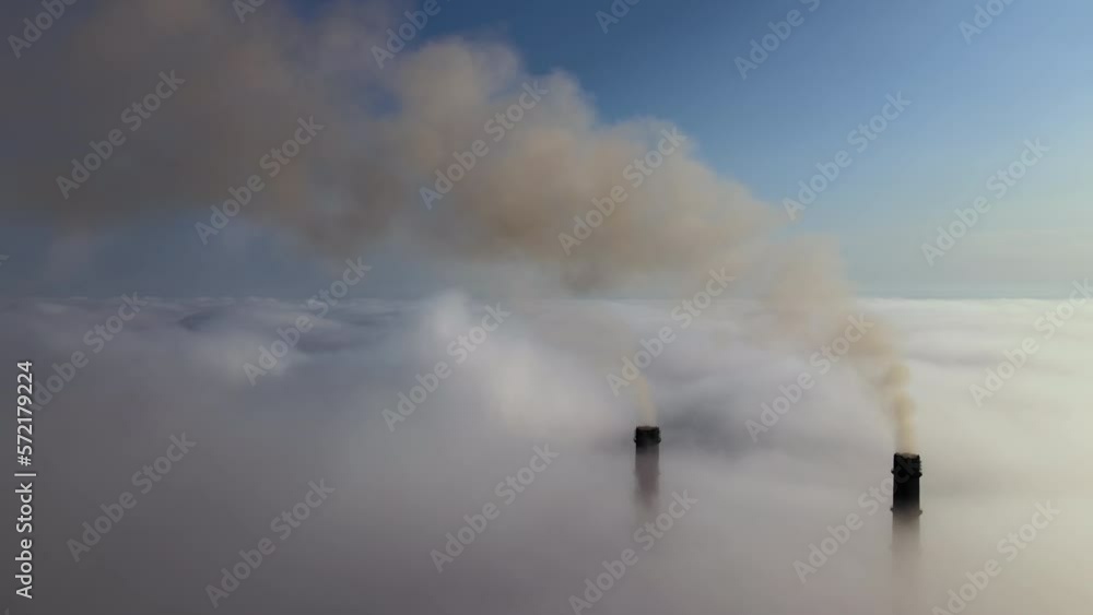 Coal power plant high pipes emitting black poisonous smoke moving upwards over white fog polluting air. Production of electrical energy with fossil fuel concept Coal power plant high pipes emitting black poisonous smoke moving upwards over white fog polluting air. Production of electrical energy with fossil fuel concept