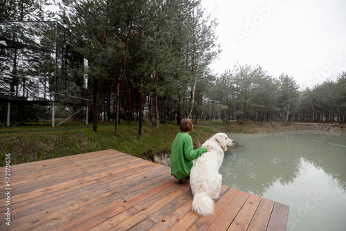 Wallpaper Mural Woman enjoys nature while sitting with her dog on pier near lake in pine forest Torontodigital.ca