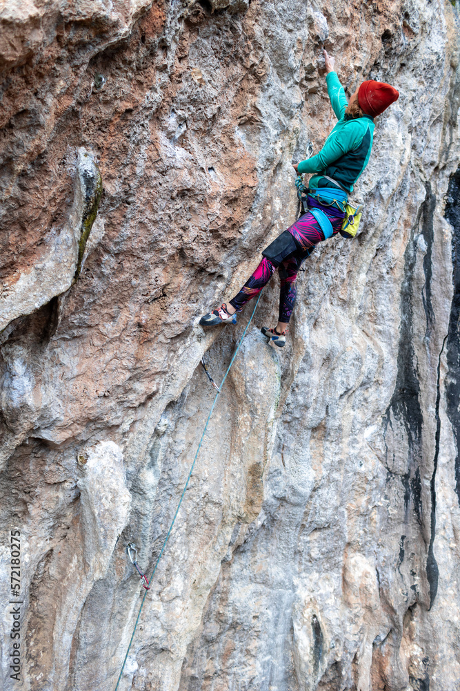 woman climbs a rock, a strong girl trains strength and endurance, extreme sport
