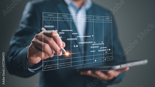 Project manager working with Gantt chart schedule to plan tasks and deliverables. Scheduling activities with a planning software, Corporate strategy for finance, operations, sales, marketing.