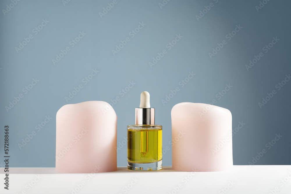 yellow face and hair oil with candles on blue background yellow face and hair oil with candles on blue background