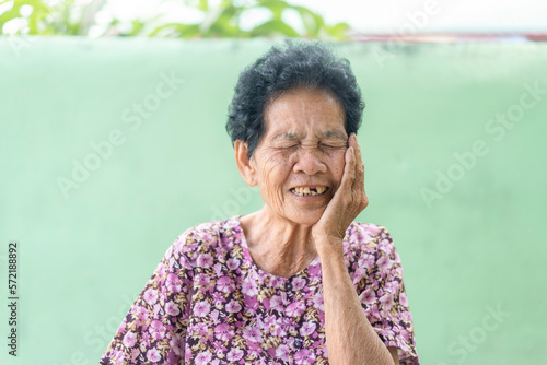 Senior black-haired woman touching the mouth with hand with painful expression because of toothache or dental illness on teeth. Mature woman suffering from toothache at home. Dentist