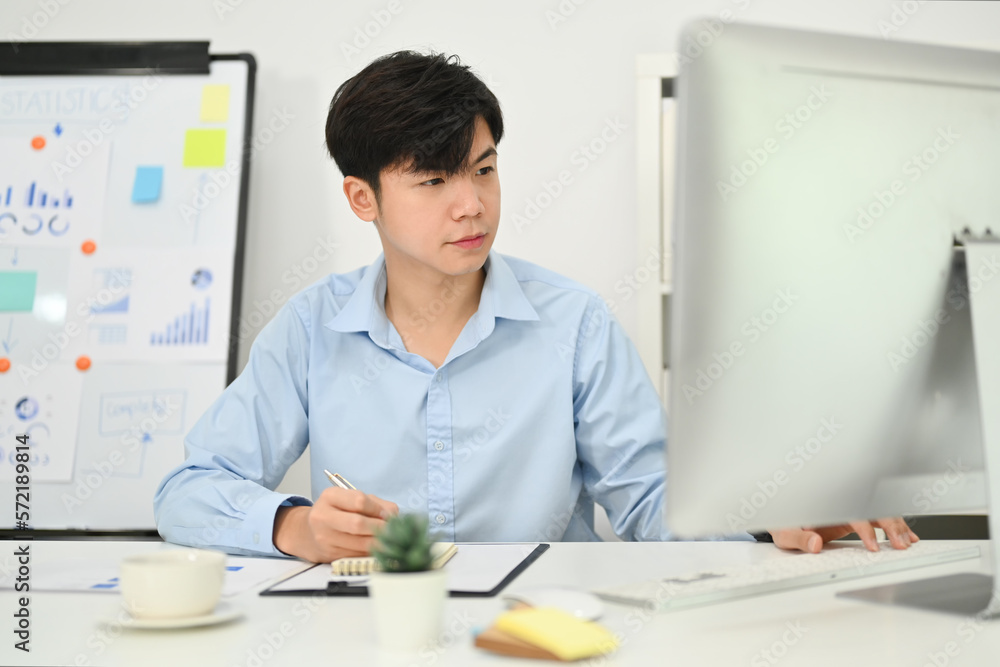 Professional young asian businessman working on commercial and marketing project at modern office