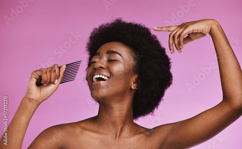 Singing black woman, hair or afro comb on background in fun grooming routine, natural skincare play or growth texture karaoke. Beauty, happy or hairstyle brush microphone on isolated pink performance