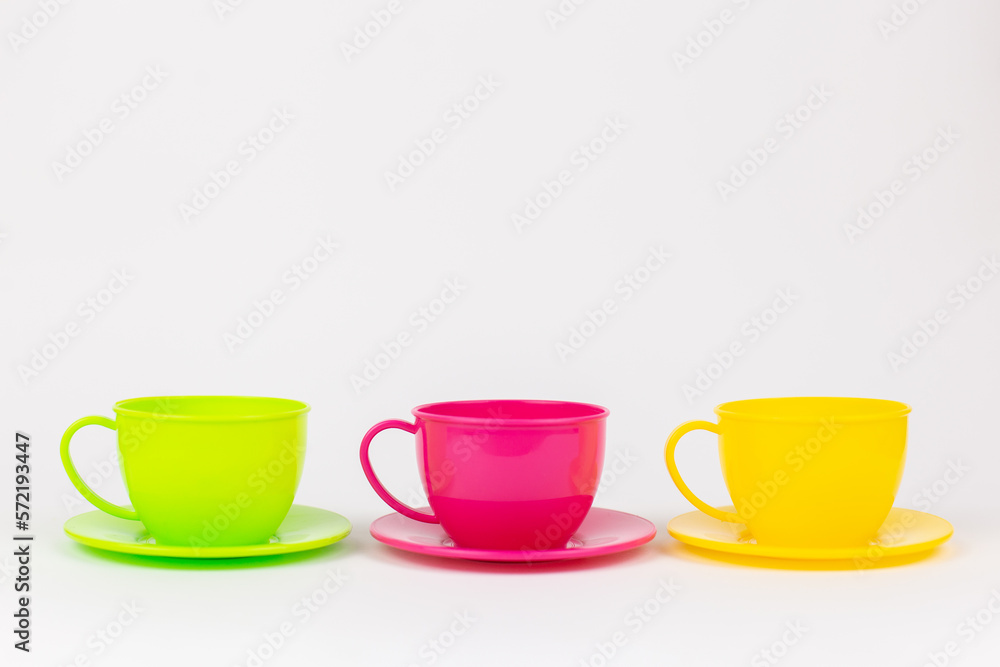 multi-colored plastic cups and plates on a white background kitchen set multi-colored plastic cups and plates on a white background kitchen set