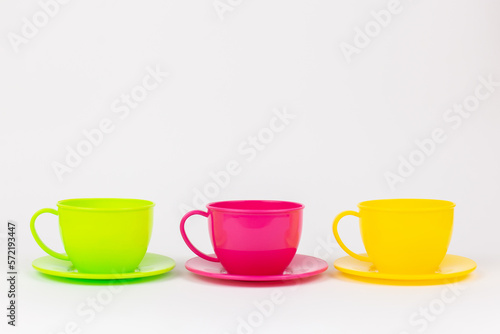 multi-colored plastic cups and plates on a white background kitchen set