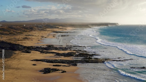 Klify oceanu atlantyckiego w Fuertaventura morze woda i plaża, surferzy i góry