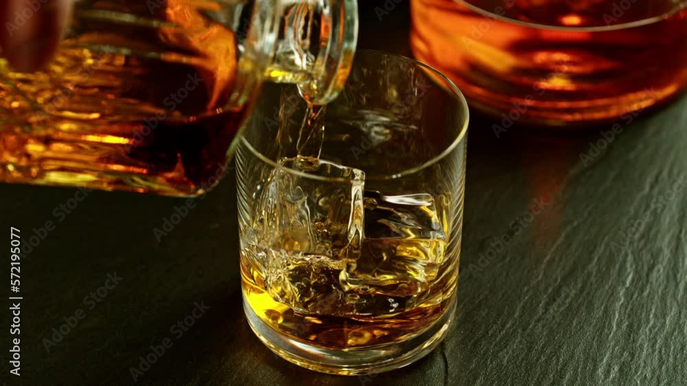 Super slow motion of falling ice cube into whiskey drink, camera motion. Filmed on high speed cinema camera, 1000 fps. Super slow motion of falling ice cube into whiskey drink, camera motion. Filmed on high speed cinema camera, 1000 fps.
